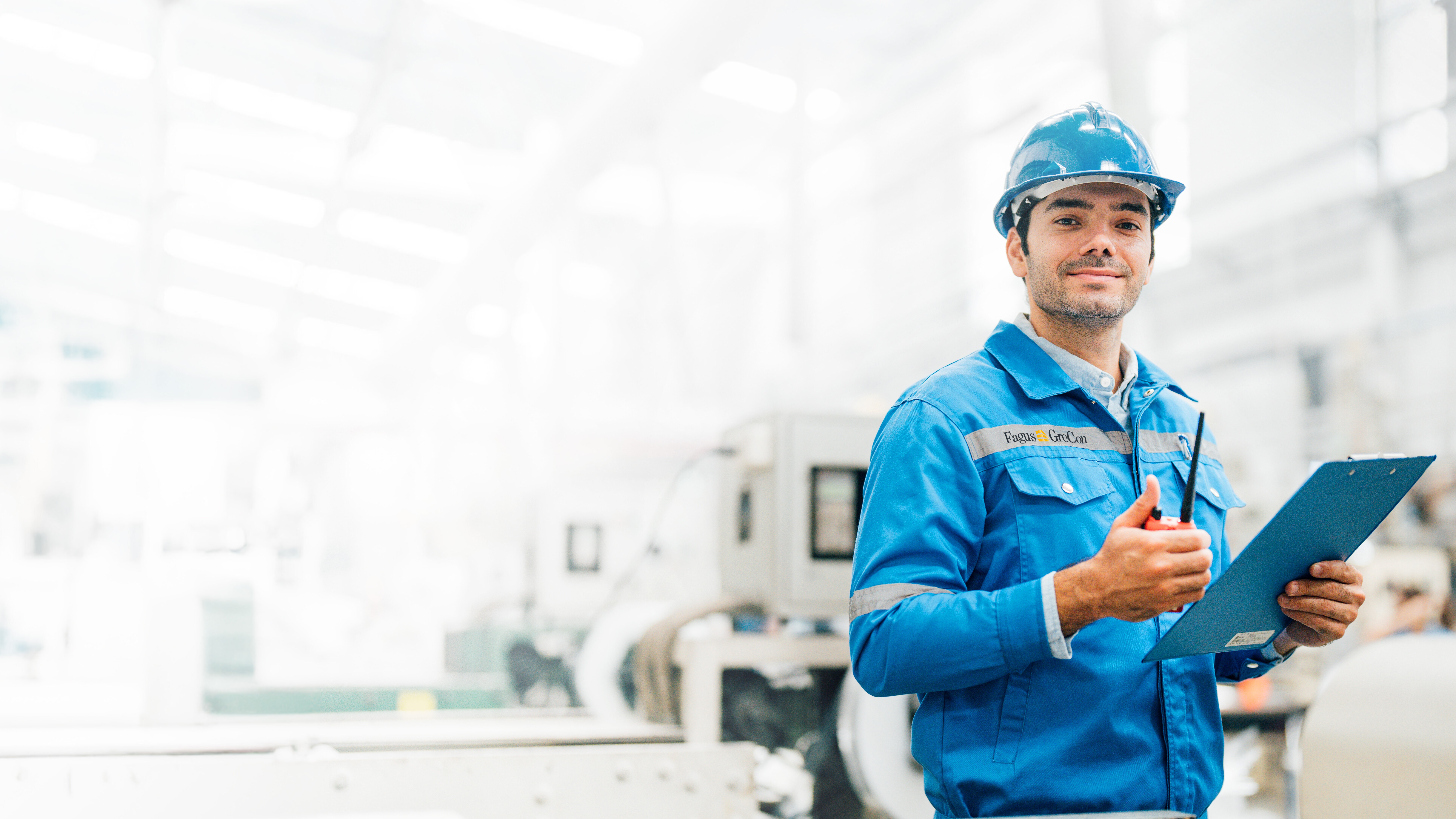 Worker in blue GreCon outfit with clipboard and helmet
