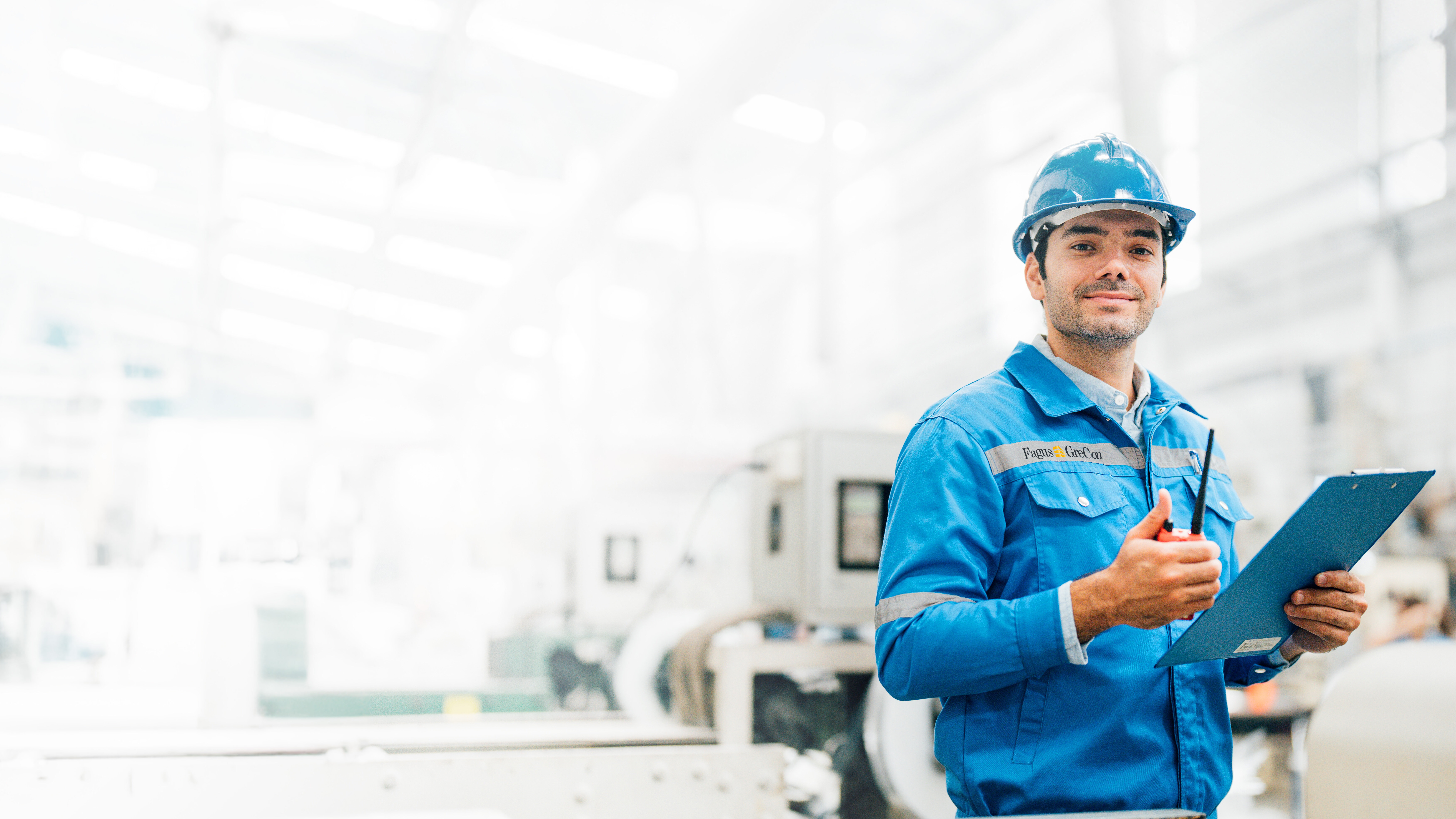 Worker in blue GreCon outfit with clipboard and helmet